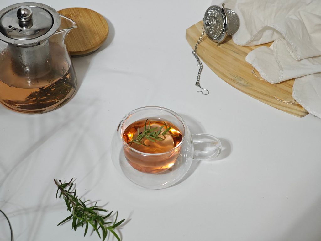 Home Elegant composition of herbal tea with rosemary on a white background, showcasing a minimalist style.